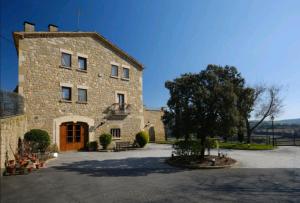 a large stone building with a tree in front of it at Casa del Moliner in Boada