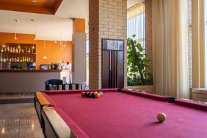 Hotel de Ilhavo Plaza & Spa في إيهافو: طاولة بلياردو وردية في غرفة مع بار