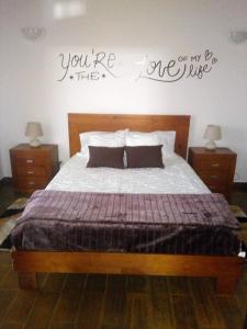 a bedroom with a bed with a sign on the wall at Casa dos Valentes in Santo Espírito
