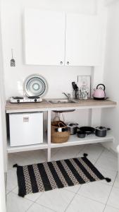 a kitchen with a counter with a sink and a rug at Casa Liaya - Villa di Matala Apartments in Matala