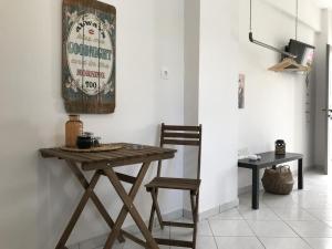 una mesa de madera y una silla en una habitación en Casa Liaya - Villa di Matala Apartments en Mátala