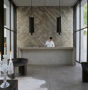 a man standing behind a counter in a bathroom at Habita Monterrey, a Member of Design Hotels in Monterrey