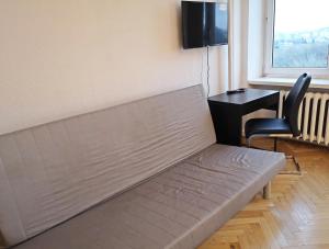 Bett in einem Zimmer mit einem Stuhl und einem Schreibtisch in der Unterkunft Smolna Tower in Warschau