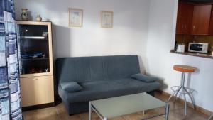sala de estar con sofá azul y taburete en Torrox Costa, en Torrox Costa