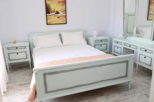 a bedroom with a white bed and a mirror at Sunshine House offering spectacular views to Olymp A in Nea Iraklia