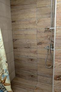 a bathroom with a shower with a wooden wall at Sunshine House offering spectacular views to Olymp A in Nea Iraklia