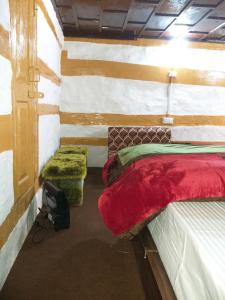 HarsilにあるMountain Village Stay - Dharali Heights Harsilのベッド2台とオットマン2台が備わる部屋