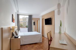 Uma TV ou centro de entretenimento em Normandy Hotel