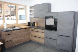 a kitchen with wooden cabinets and a stainless steel refrigerator at Appartement zur schlafenden Jungfrau in Hinterthal
