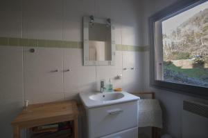 a bathroom with a sink and a mirror and a window at Appartement Talloires vue lac et montagnes in La Pirraz