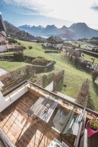 a view from the balcony of a house with a patio at Appartement Talloires vue lac et montagnes in La Pirraz