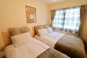 two beds sitting next to each other in a bedroom at Monteribolo Sapporo East / Vacation STAY 6005 in Sapporo
