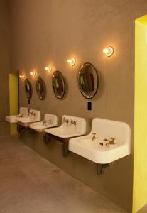 a row of sinks in a bathroom with mirrors at Downtown Beds in Mexico City