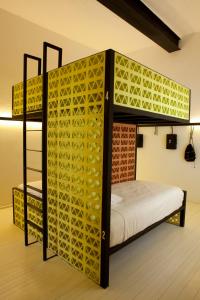 sypialnia z łóżkiem piętrowym i żółtą wzorzystą ścianą w obiekcie Downtown Beds w mieście Meksyk