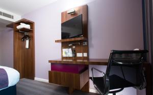a hotel room with a desk with a tv and a chair at Holiday Inn Express Lincoln City Centre, an IHG Hotel in Lincoln
