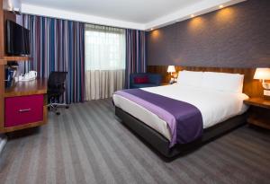 Holiday Inn Express Lincoln City Centre في لينكولن: غرفة في الفندق مع سرير ومكتب