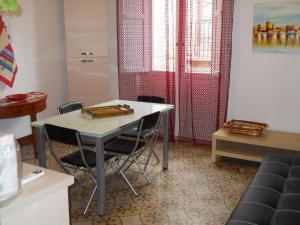 トラーパニにあるCasa Vacanze Trapani Via Mercèの赤いカーテン付きの部屋(テーブル、椅子付)