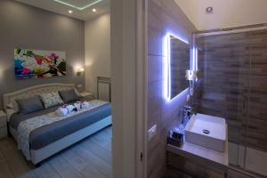 a bedroom with a bed and a bathroom with a sink at ROYAL GARDENS in Caserta +53 photos