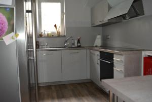 Ferienwohnung Freiraumwohnung في Tessenow: مطبخ بدولاب بيضاء ومغسلة ونافذة