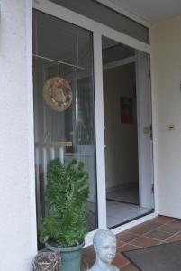 a statue in front of a glass door with a plant at Ferienwohnung Freiraumwohnung in Tessenow