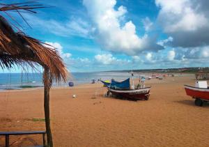 una playa con dos barcos sentados en la arena en Complejo Costa Serena-Casas del Mar, en La Paloma