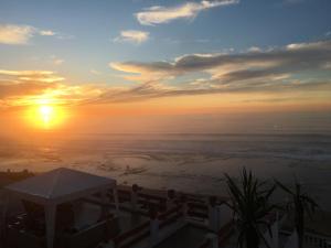 a sunset over the ocean with the sun in the sky at Villa Keltoum in Moulay Bousselham