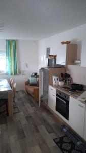 a kitchen with a stove and a couch in a room at Liebevolle Fewo im Bayerischen Wald in Witzmannsberg