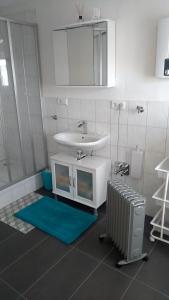 een badkamer met een wastafel, een spiegel en een radiator bij Liebevolle Fewo im Bayerischen Wald in Witzmannsberg