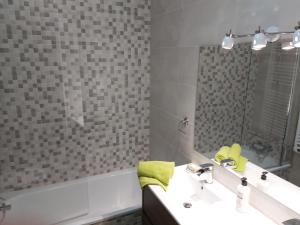 La salle de bains est pourvue d'un lavabo, d'un miroir et d'une baignoire. dans l'établissement Ski Station Apartments, à Arinsal
