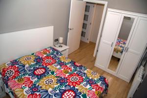 een slaapkamer met een bed met een kleurrijke sprei bij Apartamento Reus 2 - Parking gratuito in Reus