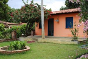 a small house with a yard with flowers at Casa Cheia de charme in Mucugê