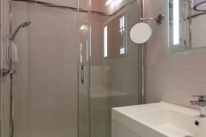 a bathroom with a glass shower and a sink at Hôtel Central Parc Oyonnax in Oyonnax