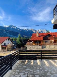 a house with a fence and mountains in the background at Nordic Chalet in Sinaia