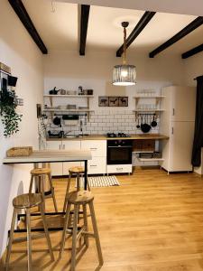 uma cozinha com armários brancos, uma mesa e bancos em Nordic Chalet em Sinaia