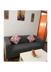 - un salon avec un canapé noir et une table blanche dans l'établissement Apartamentos cerca del Aeropuerto, à Ingenio