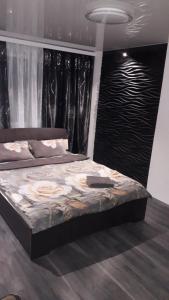 a large bed in a bedroom with black curtains at Квартира с WiFi и видом на город и р Днепр in Kamianske