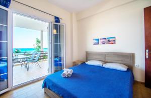 a bedroom with a blue bed and a balcony at Paradiso Del Mare On the Beach in Zakynthos Town