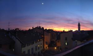 a view of a city at sunset with a clock tower at Petronilla - Hotel In Bergamo in Bergamo