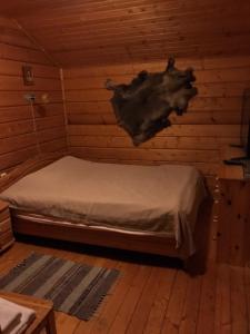 LovozeroにあるRusskaya Laplandiaのログキャビン内のベッド1台が備わる客室です。