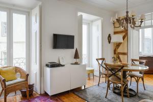 uma sala de estar com uma mesa e uma televisão em Apartamento do Carmo em Lisboa