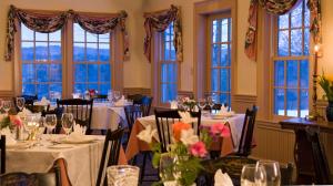 a dining room with tables and chairs and windows at Chesterfield Inn in West Chesterfield