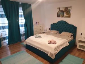 a bedroom with a large bed with a blue headboard at Garsoniera Mihaela in Onești