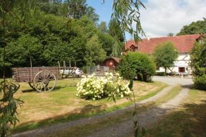 a farm with a carriage and flowers in the grass at Domaine Les Filloux in Saint-Dizier-Leyrenne
