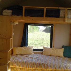 - une chambre avec des lits superposés et une fenêtre dans l'établissement Tiny house sur la Presqu'île Sauvage, à Lanmodez