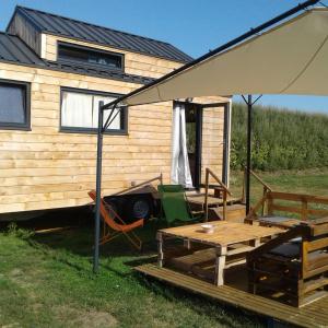 ein Haus mit einem Picknicktisch und einem Sonnenschirm in der Unterkunft Tiny house sur la Presqu'île Sauvage in Lanmodez