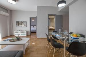 una sala da pranzo e un soggiorno con tavolo e sedie. di Cozy apartment in Syntagma-Plaka by GHH ad Atene
