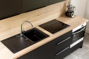 une cuisine avec un évier et un plan de travail en bois dans l'établissement Gîtes de La Vesée, à La Chapelle dʼArmentières