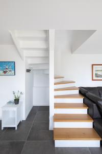 a staircase in a house with white walls and floors at La Maison De La Rade in Le Relecq-Kerhuon