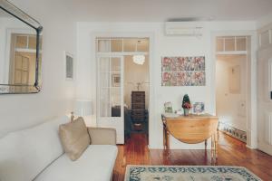 a living room with a couch and a table at Casa Dos Azulejos - Lapa in Lisbon