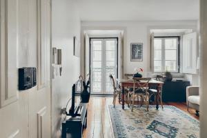 uma sala de estar com uma mesa e uma sala de jantar em Casa Dos Azulejos - Lapa em Lisboa